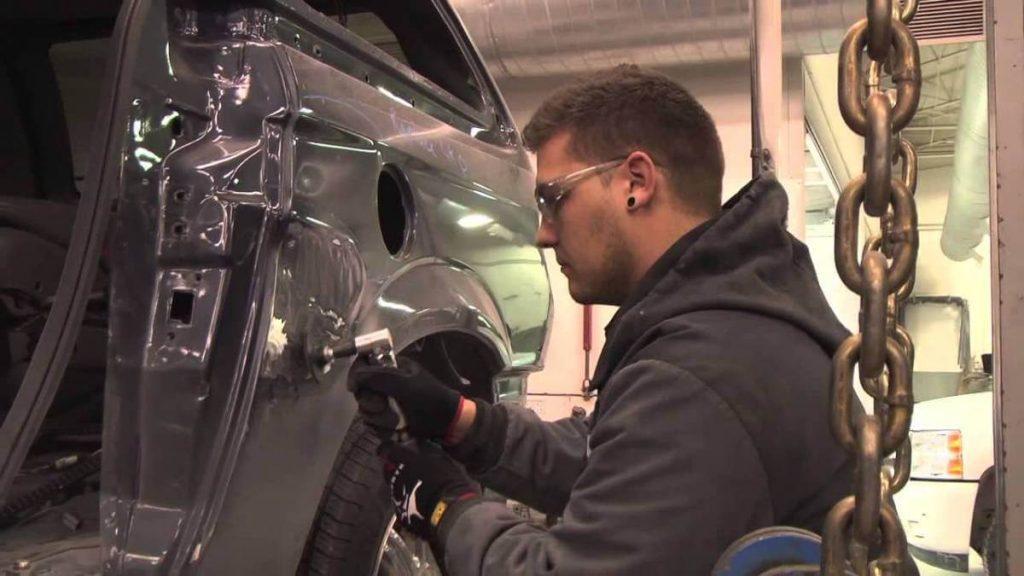 Auto body repairman using die grinder