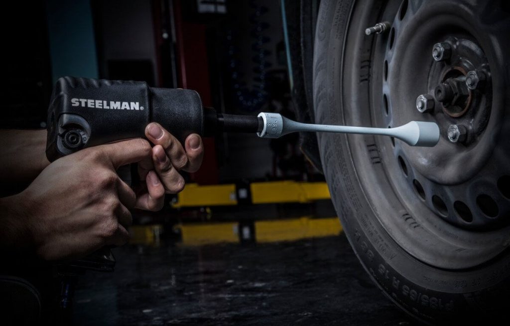 Auto mechanic using torque stick